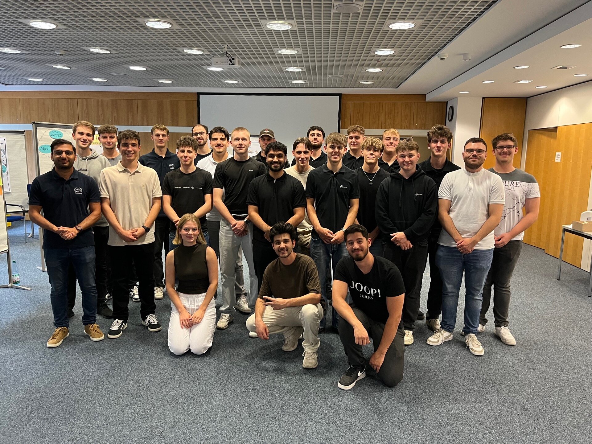  Gruppenfoto der Teilnehmenden der sozialpädagogischen Woche der Schunk Group in einem Seminarraum während des gemeinsamen Programms.